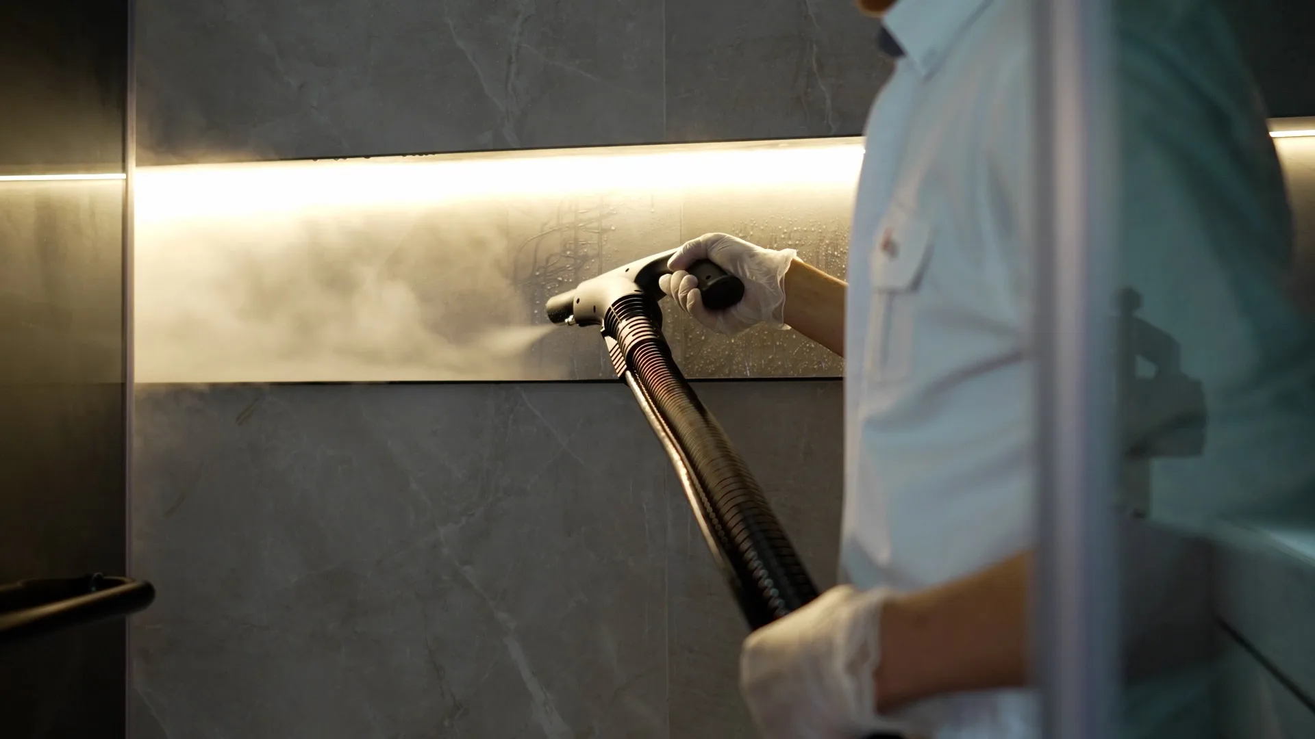 A Saniservice technician steam-cleaning a marble surface
