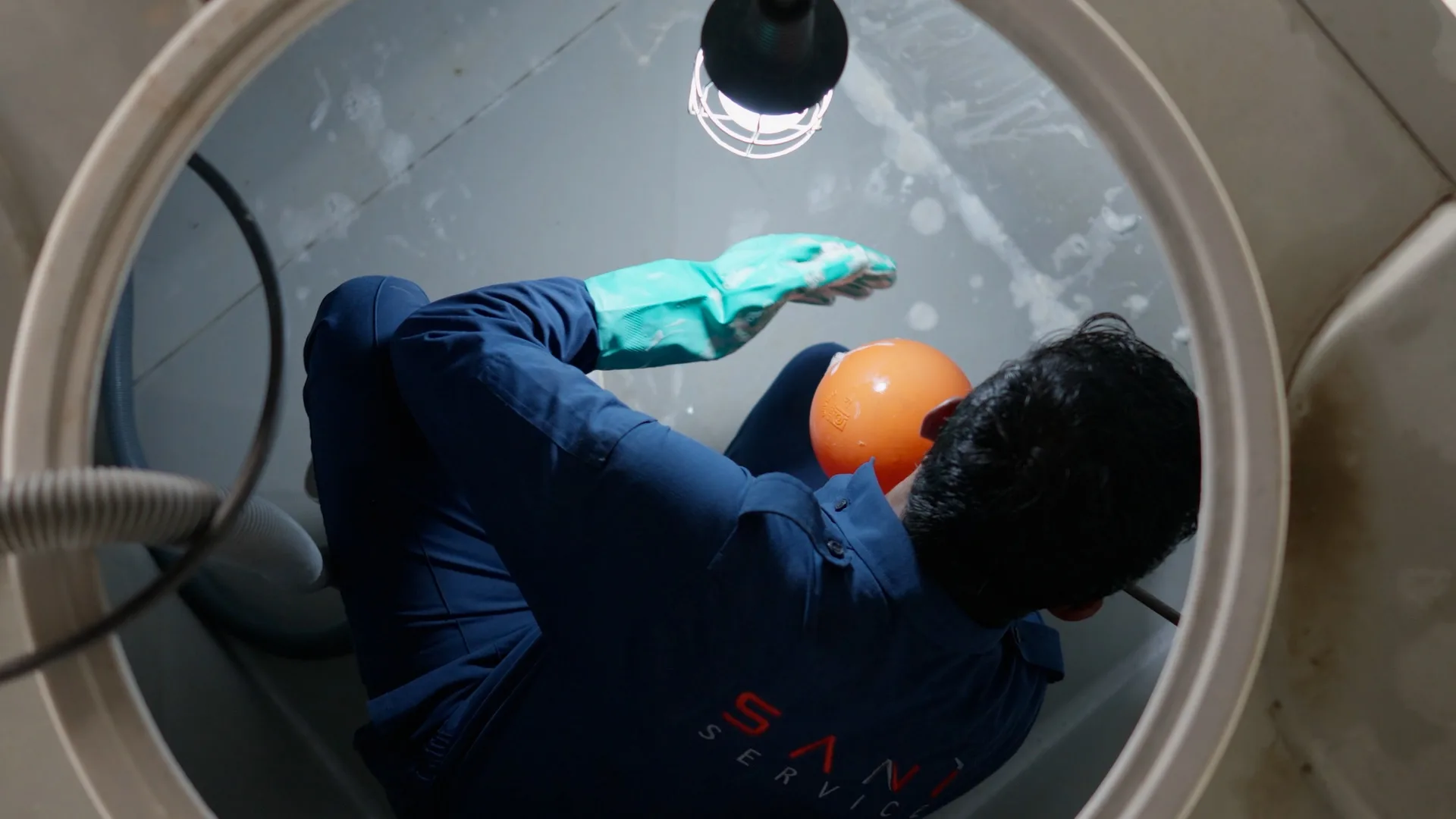 A Saniservice technician inside a water storage tank during cleaning and disinfection