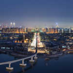 Cityscape of Dubai, United Arab Emirates at dusk, with illuminated skyscrapers in the distance and bridge across the marina in the foreground.,Dubai, United Arab Emirates