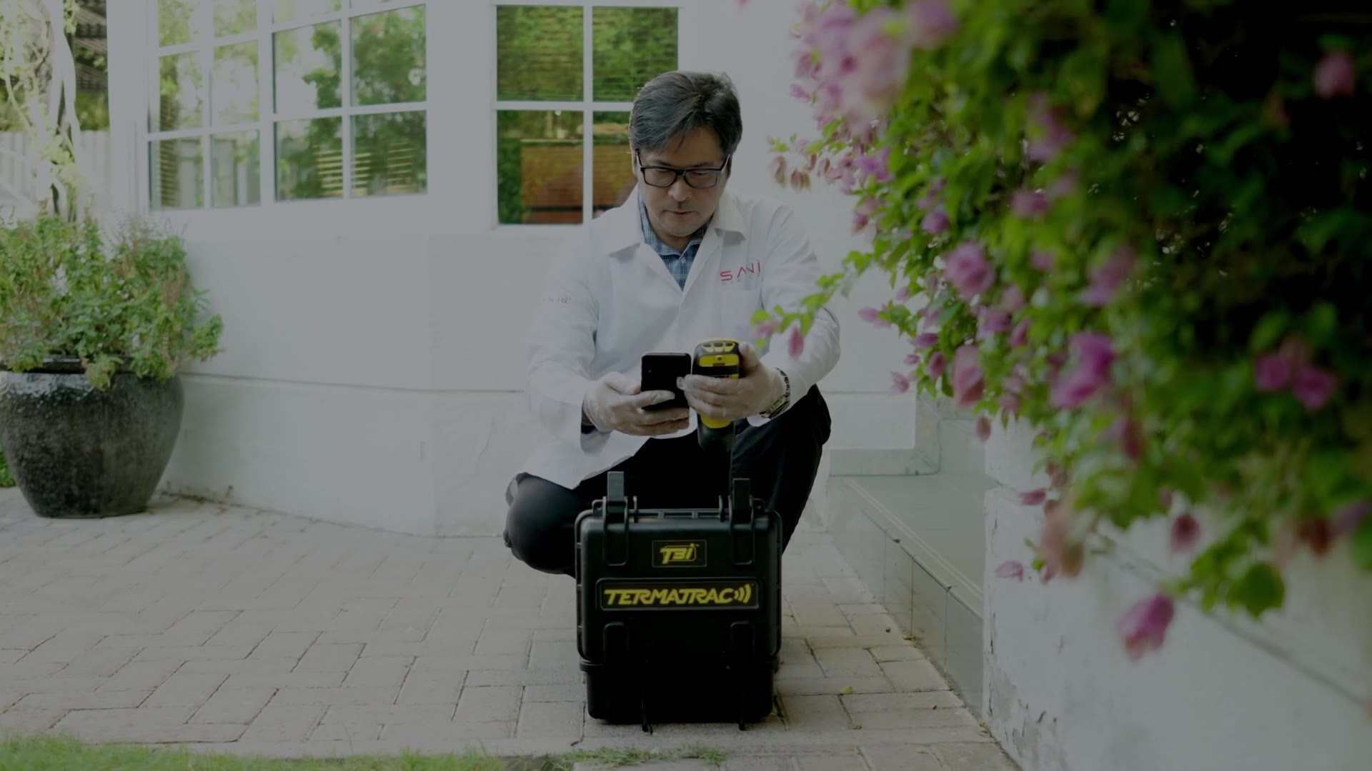The Pest Control Doctor taking Termatrac readings in a Dubai villa garden during a termite diagnosis